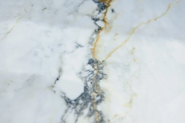 Close-up of a white marble-effect tile with grey and gold veining