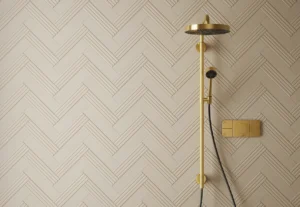 Cream ridged wall tiles in herringbone layout alongside a brushed gold shower system