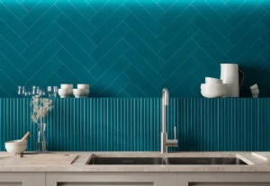 Deep teal ribbed tiles on kitchen splashback with stone worktop and sink