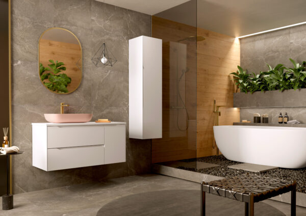 White two-drawer vanity with pink vessel basin beside freestanding bath