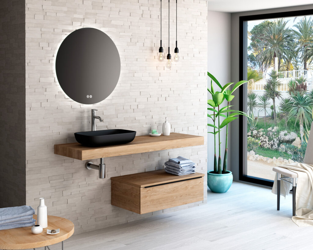 Matte black countertop basin on floating oak shelf with round backlit mirror and textured stone wall
