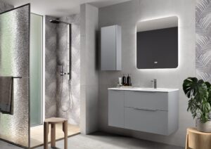 Matte grey wall hung vanity unit with backlit mirror beside a walk-in shower