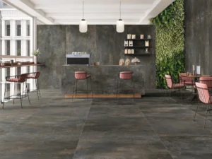 Dark iron-effect porcelain tiles on floor and walls of a modern café interior