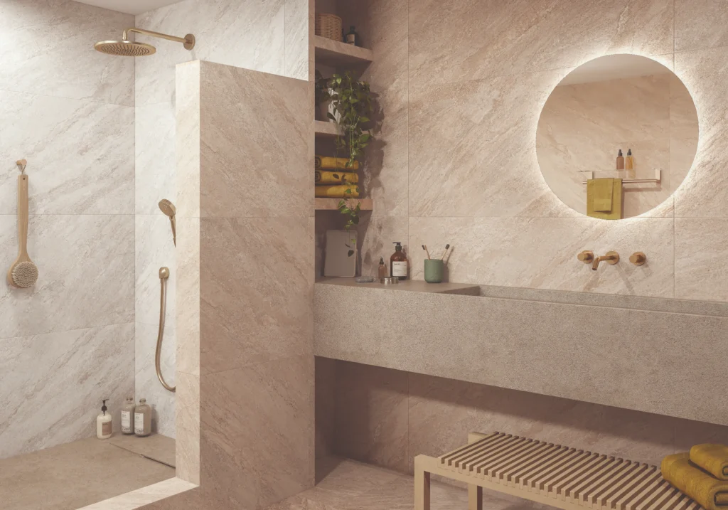Modern bathroom with white quartz-effect wall tiles, brass fittings and round backlit mirror