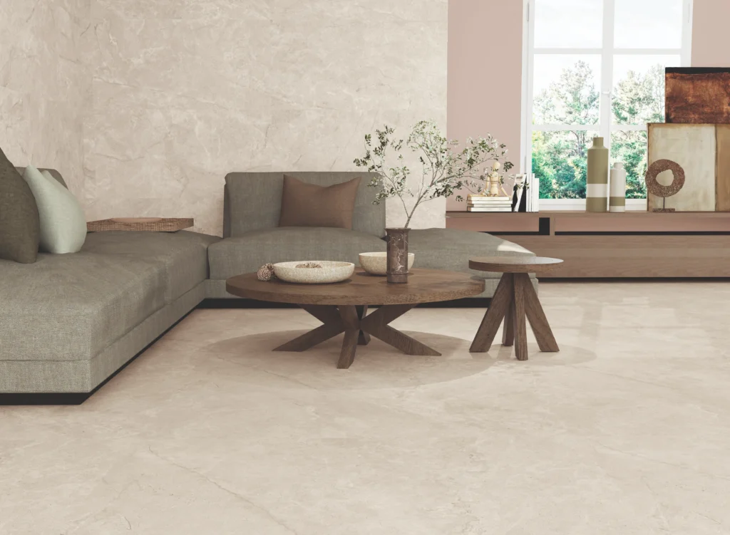 Ivory porcelain floor tiles with soft stone veining beneath a grey corner sofa