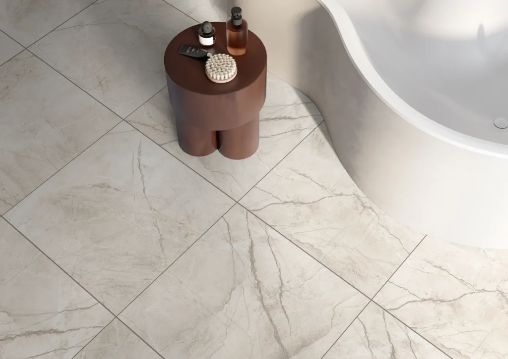 Ivory marble-effect floor tiles beside a freestanding bath and sculptural side table