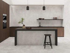 Modern kitchen featuring light grey matt tiles on floor and walls with dark cabinetry