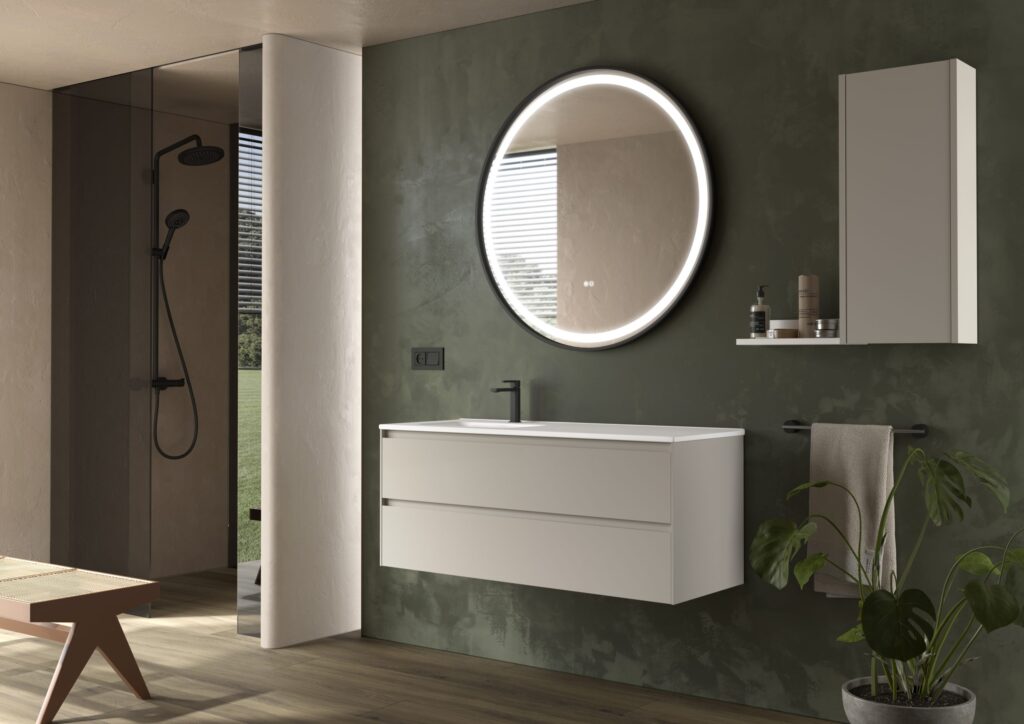 White wall hung vanity unit with round illuminated mirror against a deep green textured wall