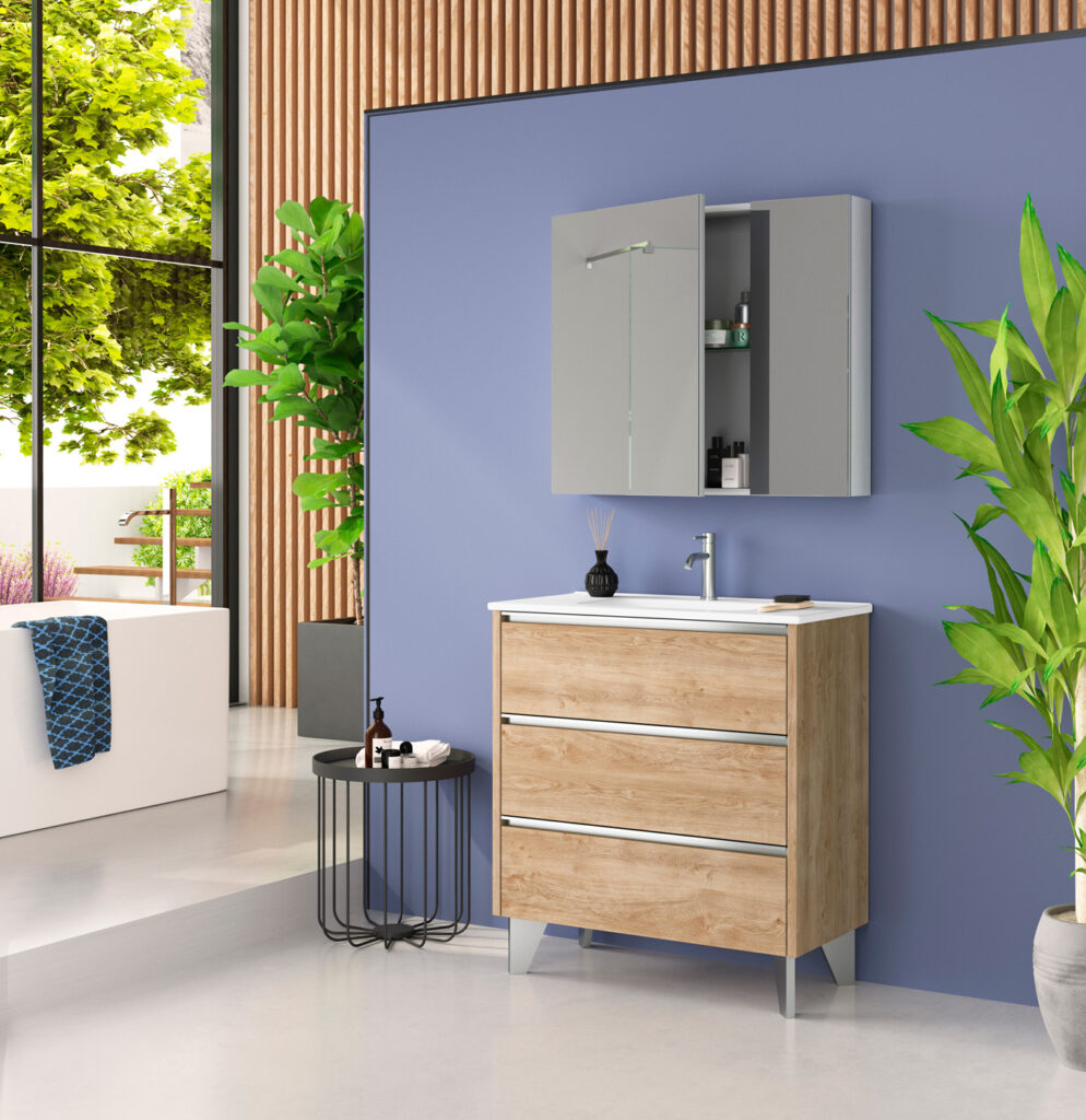 Oak three-drawer freestanding vanity with chrome handles paired with a grey mirrored cabinet