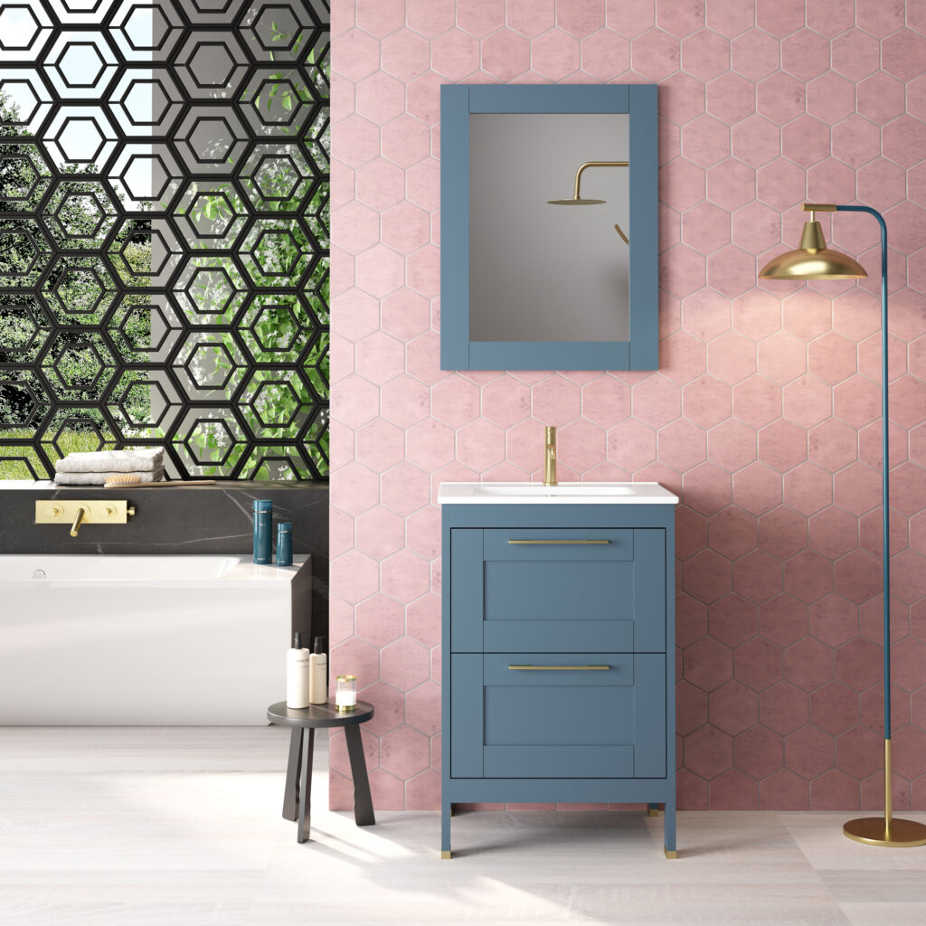 Blue vanity unit with brass handles against blush pink hexagonal tiles