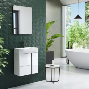 White wall hung vanity unit with black-framed mirror against a dark green geometric tiled wall