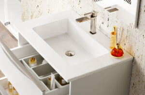 White centred washbasin with chrome tap on vanity unit, open drawer below revealing toiletries