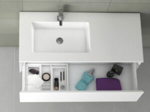 Top-down view of single inset washbasin with open drawer containing toiletries