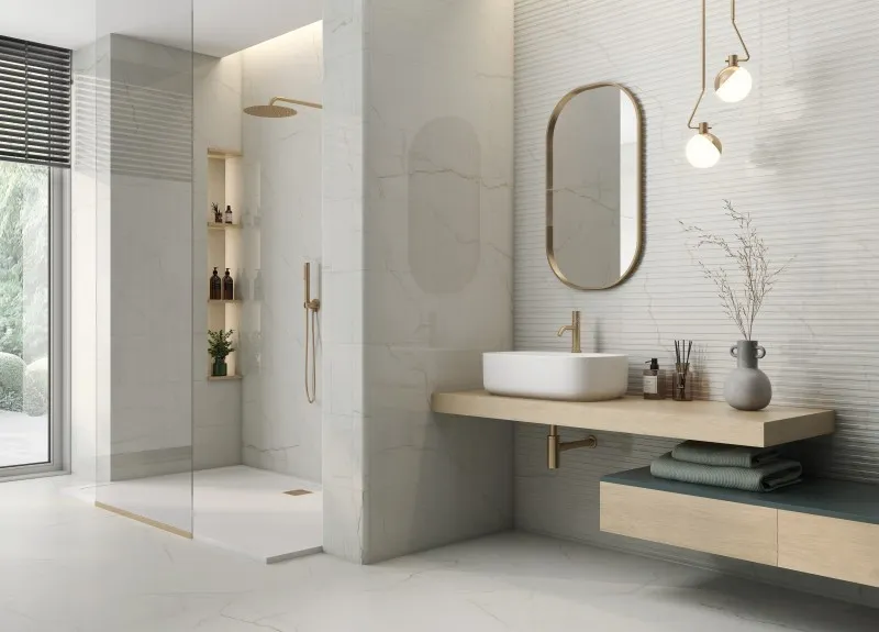 Modern bathroom with white marble wall tiles, walk-in shower and brass fixtures