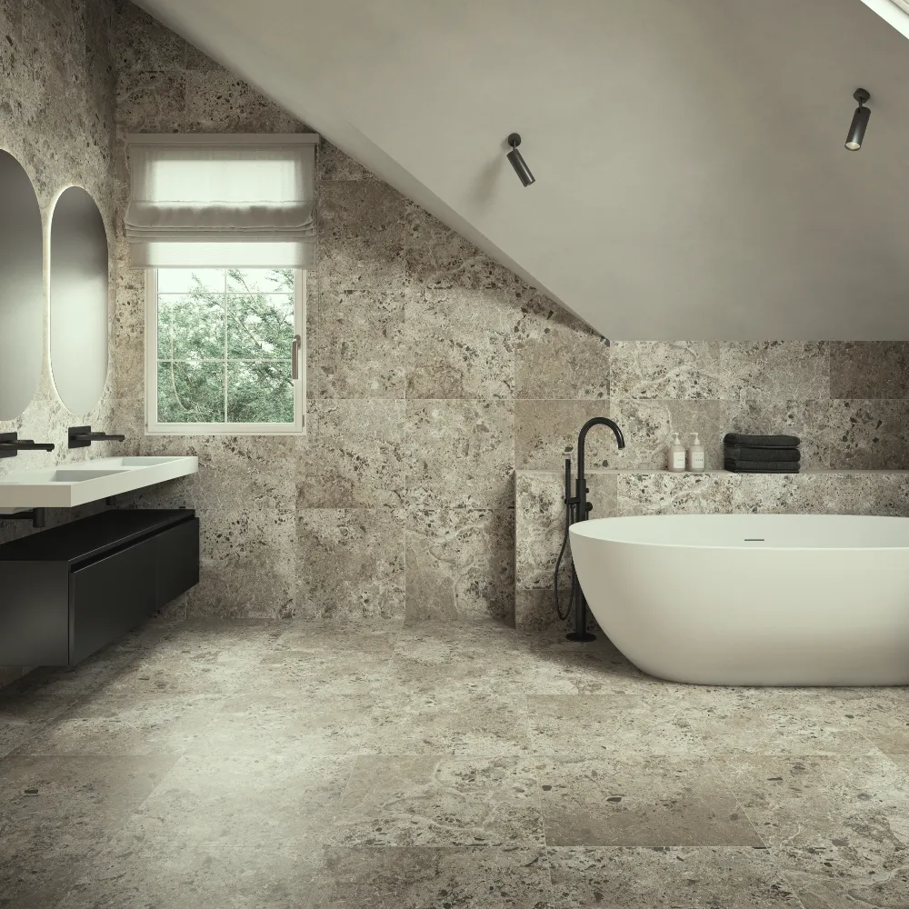 Attic bathroom clad in textured pearl stone-effect tiles with freestanding white bath
