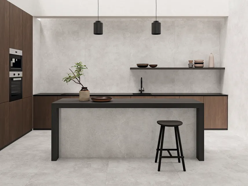 Minimal kitchen with light grey stone-effect floor and wall tiles, dark island