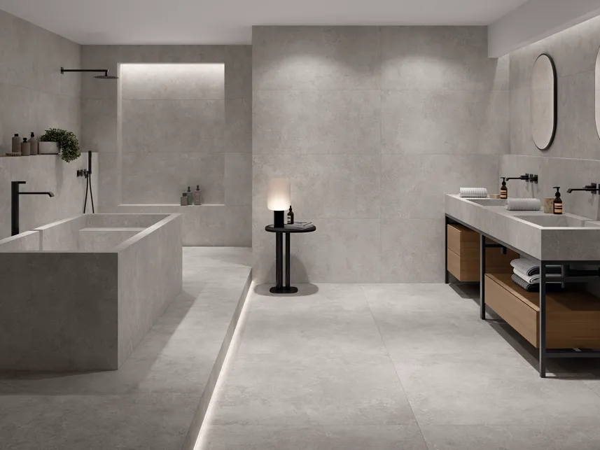 Spacious modern bathroom with grey stone-effect tiles on walls, floor, and bath surround